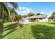 Expansive backyard with a sparkling pool, mature trees, and a view of the home's exterior at 3015 Riviera Bay Ct, Oviedo, FL 32765
