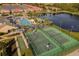 Aerial view of community sports courts including tennis and basketball, with a pool and lake at 3061 Beach Palm Ave, Kissimmee, FL 34747