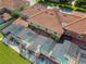 Aerial view of homes and pool area featuring a screened-in pool and tile roofs at 3061 Beach Palm Ave, Kissimmee, FL 34747