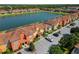 A beautiful aerial view of colorful townhomes situated alongside a serene lake in a well-maintained community at 3061 Beach Palm Ave, Kissimmee, FL 34747