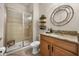 Well decorated bathroom with a shower, granite countertop, round mirror, and wooden storage shelves at 3061 Beach Palm Ave, Kissimmee, FL 34747