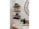 Charming bathroom shelves with plants, a black metal basket, and round mirror, complemented by granite countertops at 3061 Beach Palm Ave, Kissimmee, FL 34747