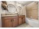 Well decorated bathroom with double sinks, wooden cabinets, granite countertops, and decorative round mirrors at 3061 Beach Palm Ave, Kissimmee, FL 34747