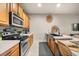 Functional kitchen with stainless steel appliances, wooden cabinets, and concrete counters at 3061 Beach Palm Ave, Kissimmee, FL 34747