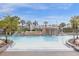 Resort-style pool with a waterfall feature, palm trees and spacious deck area at 3061 Beach Palm Ave, Kissimmee, FL 34747