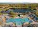 Aerial view of a large community pool with palm trees, lounge chairs and waterslides at 3061 Beach Palm Ave, Kissimmee, FL 34747