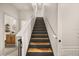 Bright and airy staircase with wood and dark painted risers, plus a modern white handrail at 3061 Beach Palm Ave, Kissimmee, FL 34747