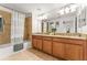 Bathroom featuring a tiled tub and shower combination, dual sinks, and granite countertops at 3193 Pequod Pl, Kissimmee, FL 34746