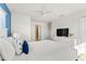 Bright bedroom with white walls, a ceiling fan, and a plush bed accented with blue pillows at 3193 Pequod Pl, Kissimmee, FL 34746