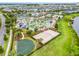 Aerial view showcasing community amenities like a pool, sports courts, and a lake at 3193 Pequod Pl, Kissimmee, FL 34746