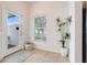 Bright entryway with tile flooring, window with blinds, decorative plant, and white front door with glass insert at 3193 Pequod Pl, Kissimmee, FL 34746