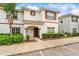Charming two-story townhouse with a brown front door, white exterior, and neatly landscaped yard at 3193 Pequod Pl, Kissimmee, FL 34746