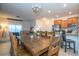 Open-concept kitchen and dining area with a large wood table, stainless steel appliances, and modern finishes at 3193 Pequod Pl, Kissimmee, FL 34746