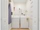Clean and functional laundry room with a washer, dryer, and ironing board at 3193 Pequod Pl, Kissimmee, FL 34746
