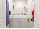 Bright laundry room featuring washer, dryer, ironing board, and shelf with cleaning supplies at 3193 Pequod Pl, Kissimmee, FL 34746
