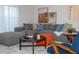 Stylish living room with a plush gray sectional, vibrant decor, elegant artwork, and natural light, creating a cozy atmosphere at 3193 Pequod Pl, Kissimmee, FL 34746