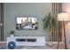 Stylish living area featuring a modern TV, sleek entertainment center, wood-accent wall and elegant decor at 3193 Pequod Pl, Kissimmee, FL 34746