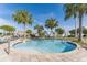 Community pool surrounded by lounge chairs, palm trees, and clear blue sky at 3193 Pequod Pl, Kissimmee, FL 34746