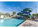 Resort-style pool featuring a large water slide, palm trees, and clear blue water at 3193 Pequod Pl, Kissimmee, FL 34746