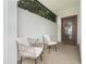 Inviting front porch featuring neutral outdoor chairs, a side table, and a textured white accent wall at 3193 Pequod Pl, Kissimmee, FL 34746