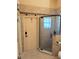 Well-lit bathroom featuring a corner glass shower, door to the back yard, and neutral tile at 32645 Red Oak Dr, Eustis, FL 32736