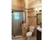 Well-lit bathroom featuring a corner glass shower, toilet, sink, and neutral tile at 32645 Red Oak Dr, Eustis, FL 32736