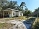 Backyard view of the building, showing solar panels, AC unit, and the surrounding trees at 32645 Red Oak Dr, Eustis, FL 32736
