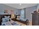 Cozy bedroom with twin beds, sports decor, and natural light from the window at 33604 Seattle Slew Dr, Sorrento, FL 32776