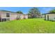 Spacious backyard showcasing the home's exterior, lawn, and shed at 4051 Crofford Ave, Haines City, FL 33844