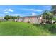 Backyard view of a single-story home featuring a spacious lawn and bright sky at 4051 Crofford Ave, Haines City, FL 33844