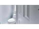 A small bathroom with a white toilet and white door with a light blue wall at 4051 Crofford Ave, Haines City, FL 33844