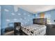 Bedroom with cloud-themed painted walls, a wooden headboard, and neutral-toned bedding at 4051 Crofford Ave, Haines City, FL 33844