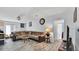 Well-lit living room with a large sectional sofa, tile flooring, and an open doorway at 4051 Crofford Ave, Haines City, FL 33844