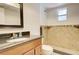 Well-lit bathroom featuring a granite countertop vanity and tiled shower with diamond-patterned accents at 422 S Hawthorn Cir, Winter Springs, FL 32708