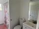 Bathroom with a white toilet, sink, mirror, and shower with a patterned curtain at 5118 Laval Dr, Orlando, FL 32839
