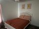 Bedroom with a white bedframe and orange bedding, illuminated by soft natural light at 5118 Laval Dr, Orlando, FL 32839