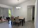 The dining room offers neutral walls and an elegant light fixture to amplify the dining experience at 5118 Laval Dr, Orlando, FL 32839