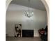 A minimalist living room features a modern chandelier, TV, and modern artwork at 5118 Laval Dr, Orlando, FL 32839