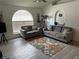A modern living room showcasing couches, area rug and a large arched window for natural light at 5118 Laval Dr, Orlando, FL 32839