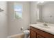 Cozy half bathroom features a wood vanity, toilet, and window providing natural light at 5669 New Independence Pkwy, Winter Garden, FL 34787