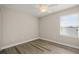 Simple bedroom with wood-look floors, ceiling fan, and natural light from the window at 5669 New Independence Pkwy, Winter Garden, FL 34787