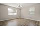 Bright bedroom with wood-look floors, chandelier, and two windows at 5669 New Independence Pkwy, Winter Garden, FL 34787