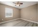 Cozy bedroom featuring wood-look floors, a ceiling fan, and a bright window at 5669 New Independence Pkwy, Winter Garden, FL 34787
