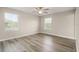 Bright bedroom featuring wood-look floors, two windows, and a ceiling fan at 5669 New Independence Pkwy, Winter Garden, FL 34787