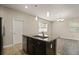 Functional kitchen island featuring dark wood cabinets, granite countertops, a sink, and stainless steel dishwasher at 5669 New Independence Pkwy, Winter Garden, FL 34787