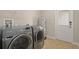 Bright laundry room features stainless steel Samsung washer and dryer with tile flooring at 5669 New Independence Pkwy, Winter Garden, FL 34787