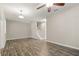 Spacious living area with wood-look flooring, ceiling fan, and staircase leading to the upper level at 5669 New Independence Pkwy, Winter Garden, FL 34787