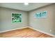 A bright bedroom with wood-look flooring and two windows for natural light at 5938 Marlberry Dr, Orlando, FL 32819