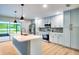 Modern kitchen features an island, stainless steel appliances, stone backsplash, light colored cabinets, and open design at 5938 Marlberry Dr, Orlando, FL 32819