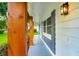 Covered front porch featuring natural wood posts, gray shutters, new siding, and modern outdoor lighting fixture at 5938 Marlberry Dr, Orlando, FL 32819